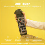 A black water bottle, featuring a pixelated game design, is held; its flip top opens one-handed. The bottle sits against a yellow background. 