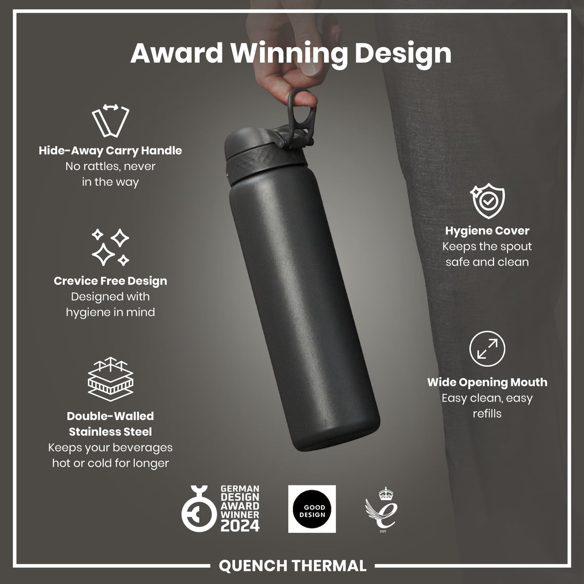 A dark-grey, double-walled stainless steel water bottle is held by a hand; it features a hide-away handle, crevice-free design, hygiene cover, and wide mouth. The bottle is an award-winning design.