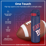 A slim stainless steel water bottle, featuring a flip top that opens one-handed, rests beside an American football. The bottle's design includes the New York Giants logo. 