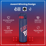 A slim stainless steel water bottle, displaying a New York Giants logo, sits against a red and blue background. Award logos are featured, along with details about its handle, hygiene design, and wide mouth. 