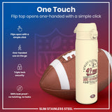 A cream-colored, slim stainless steel water bottle with a flip top rests next to an American football. The bottle is one-handed, opens with a simple click, and features 