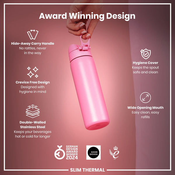 A pink, double-walled stainless steel water bottle is held by a hand. Its features include a hide-away carry handle, crevice-free design, hygiene cover, and wide opening mouth. It's an award-winning design.