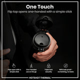 A black thermal flask's flip top is opened one-handed via a simple click by a person wearing a suit.