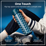 A teal water bottle with a wavy design is held; its flip top opens one-handed. The context is a person wearing casual clothes against a blue background. One Touch. Flip top opens one-handed with a simple click. Flips open with a simple click. One-handed use on the go. Triple lock security. 100% leak proof - no twisting, no leaks. SLIM THERMAL.