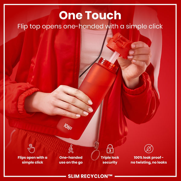 A red water bottle is being opened one-handed by a person wearing a red jacket. The bottle's top flips open with a simple click; it is leakproof and designed for one-handed use.