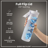 A water bottle with a full flip lid, is being held, against a gray background. The lid folds back 240°. The bottle features a blue and gray camouflage design, and the text “QUENCH RECYCLON™” is visible.