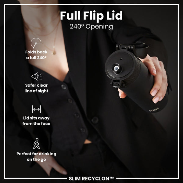 A black water bottle with a full flip lid is held by a person wearing black clothing. The lid opens 240 degrees, sits away from the face, and provides a clear line of sight. It is advertised as perfect for on-the-go drinking. SLIM RECYCLON™
