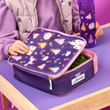 A child's purple lunchbox with princess and unicorn patterns is being opened. It's on a wooden table with a matching water bottle. The label reads ION8 Amelia.