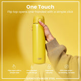 A yellow stainless steel water bottle is held; its flip top opens one-handed via a simple click. The bottle features a triple lock security mechanism and is 100% leakproof. It is showcased against a yellow background.