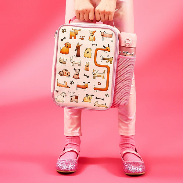 Lunchbox with cartoon dog illustrations held by a person in pink pants and sparkly shoes against a pink background Water bottle in side pocket