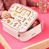Lunchbox featuring cartoon animal designs is being opened by child wearing pink sweater at table; contains snacks with visible text: 