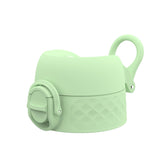 A pastel green silicone bottle cap with a spout cover and decorative diamond pattern has a loop for carrying set against a plain white background.