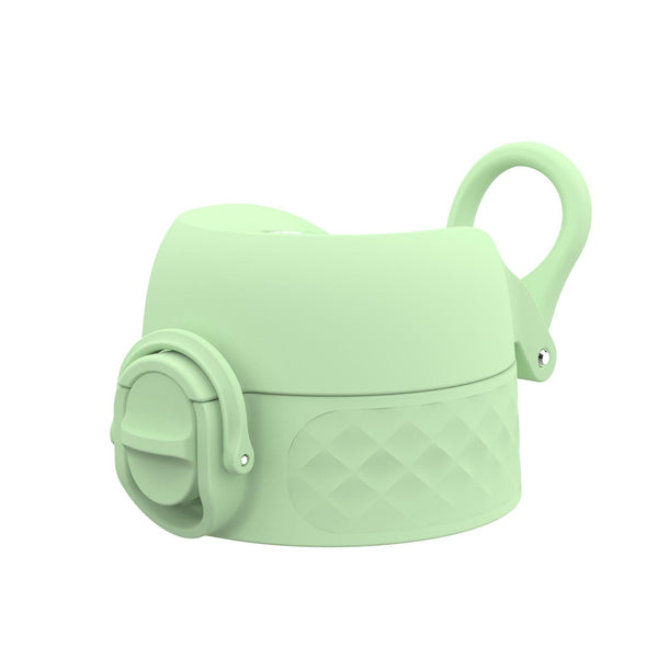 A pastel green silicone bottle cap with a spout cover and decorative diamond pattern has a loop for carrying set against a plain white background.