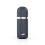 A sleek dark gray insulated bottle stands upright featuring a silver band in the middle on a plain white background with 