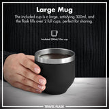 A hand holds an insulated black mug filled with liquid on a marble surface. Text reads 