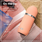 A peach-colored travel flask lies on a striped cloth beside sunglasses and a magazine on the sand. Text reads 