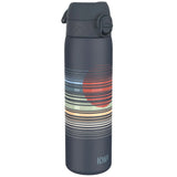 A dark gray water bottle stands upright featuring horizontal colorful stripes and a red circle design with the text 