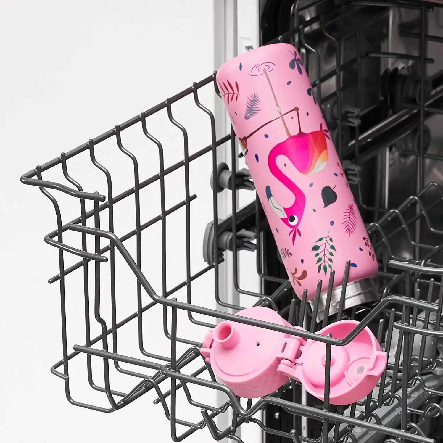 A pink flamingo-patterned water bottle is being cleaned inside a dishwasher's utensil basket.