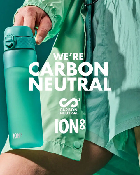 A teal water bottle is held by a person, against a teal background. The text reads: WE'RE CARBON NEUTRAL ∞² CARBON NEUTRAL ION8.
